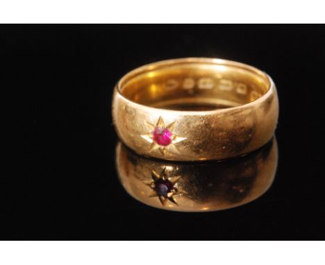 A 22ct hallmarked D shaped wedding ring gypsy set with central ruby, weight 8gm, Birmingham 1881, ring size P. 