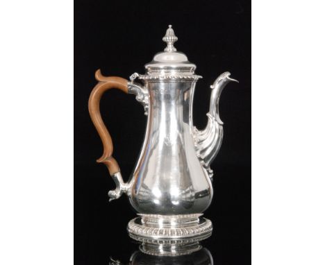 A George II hallmarked silver coffee pot, gadroon circular foot below plain baluster body part fluted spout and turned wooden