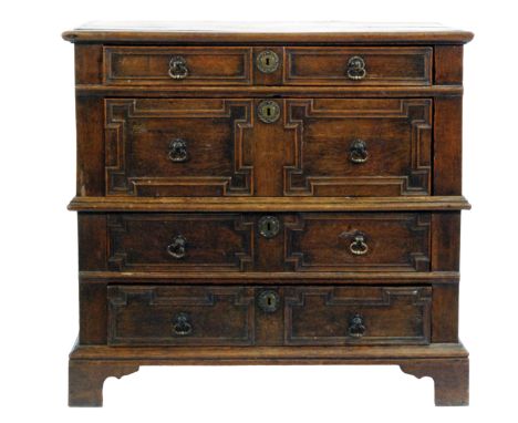 An oak chest of four long panel fronted drawers in the 17th Century style, with later top and bracket feet, in two sections, 