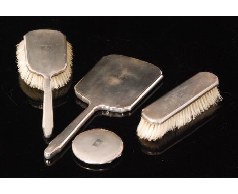 A hallmarked silver circular powder compact with engine turned decoration, together with a silver backed three piece brush an