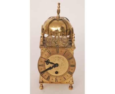 An early 20th Century Smiths brass lantern clock, Roman numerals to circular chapter ring, below domed pediment, height 25cm.