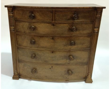 A 19th Century mahogany bow-fronted chest of two short over three long drawers, with reeded and twisted pilaster supports, la
