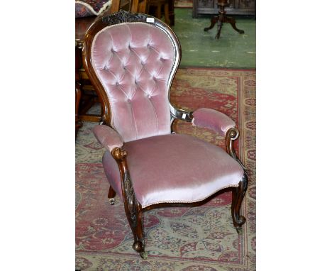 A Victorian mahogany spoonback salon armchair, button upholstered back, padded open arms, stuffed overseat, cabriole forelegs