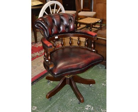 A modern office Captain's swivel chair, button upholstered back, spindled horse shoe padded arm rail, padded seat, five flute