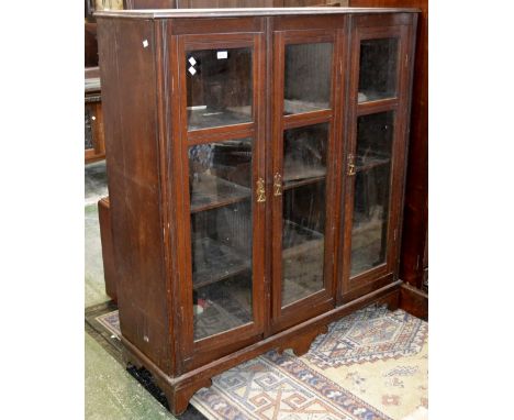 An Edwardian mahogany bookcase, moulded top, three glazed doors enclosing shelving, bracket feet. 145cm high x 132cm wide x 4