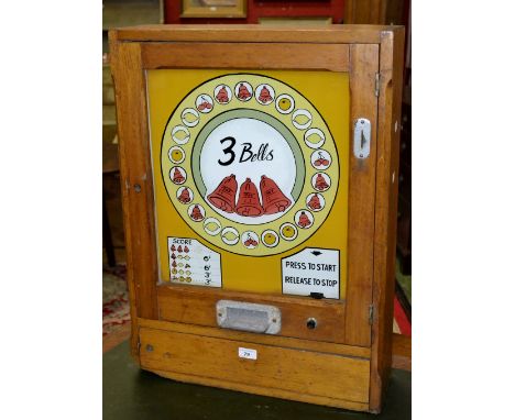 A vintage wall mounted 3 Bells flashing light fruit machine dated 1963.