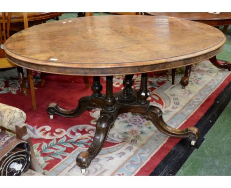 A Victorian walnut centre table, oval quarter veneered tilt top, four spreading cylindrical fluted columns, turned underfinia