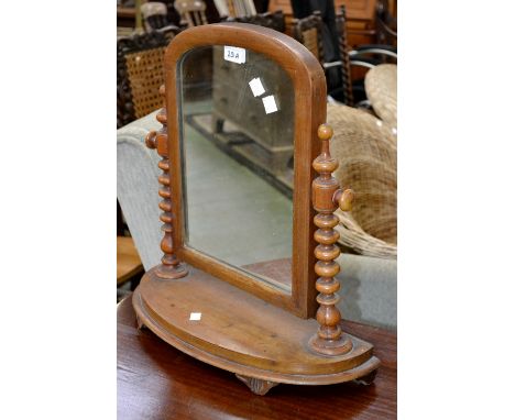 A Victorian mahogany dressing mirror, arched plate, bobbin turned uprights, demi-lune base, circa 1880.