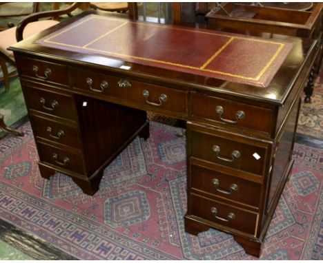 A reproduction mahogany pedestal desk, leather inlaid top, one long and two short drawers to frieze, swan neck swing handles,