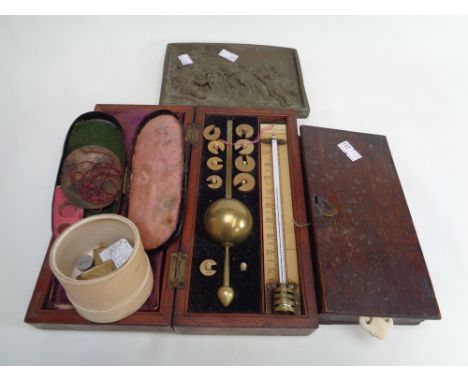 T S Winter & Sons of Newcastle Bone cased measure set, 2 cased balance sets and a plaque depicting Cherubs