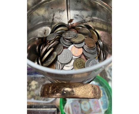 A tin of assorted coins and a gold plated bangle.  