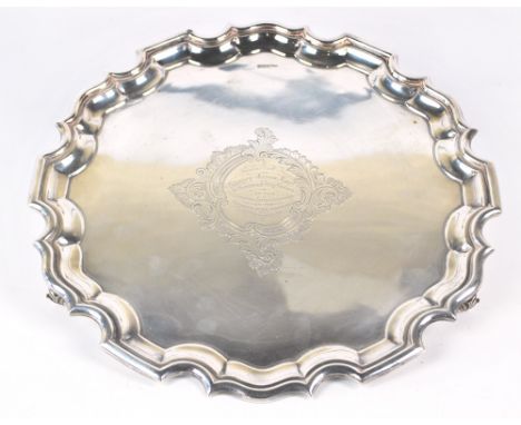 WALKER & HALL; a George V hallmarked silver salver with shaped rim on whorl style feet with central presentation inscription 
