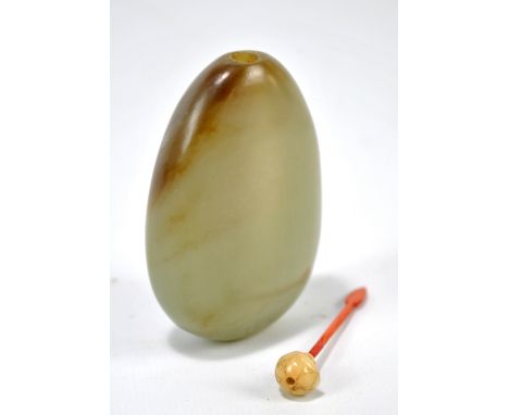 A Chinese Qianlong period pale green and brown snuff bottle of plain oval form with floral carved fat jade topper and stained