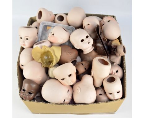 A large quantity of predominantly modern manufacture ceramic doll components comprising heads, torsos, arms and hands, legs, 