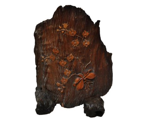 A decorative curved piece of tree trunk with inset lotus blossom and bulb decoration, on two wooden stands, possibly a fire s
