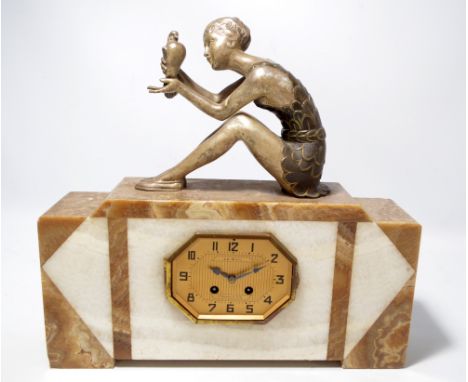 A 1950s Art Deco style two tone mantel clock surmounted with a silvered spelter figure of seated girl holding a dove, the oct