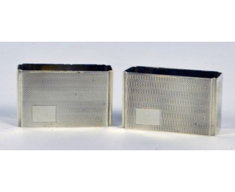 ROBERT PRINGLE; a pair of George V hallmarked silver engine turned decorated napkin rings of rectangular form with re-entrant