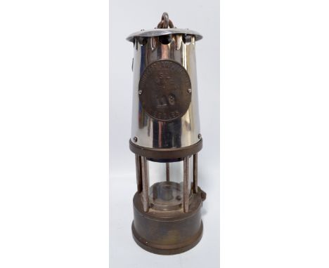 An early to mid-20th century miner's safety lamp stamped 'The Protector Lamp & Lighting Co Ltd Type SLM & Q [...] Eccles' and