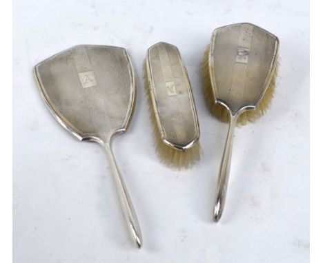 CHARLES S GREEN & CO LTD; an Elizabeth II hallmarked silver three piece dressing table set, comprising a hand mirror, a hand 