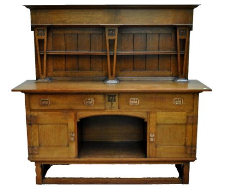 An Arts and Crafts oak dresser with boarded two shelf plate rack, two drawers above central potboard section flanked by cupbo