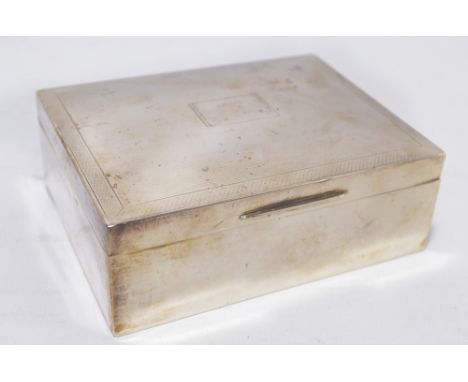 A mid 20th century hallmarked silver cigarette box, the engine turned hinged lid centred with a rectangular vacant cartouche,