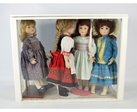 A group of bisque porcelain headed dolls with glass eyes and painted features with ceramic arms and legs on stuffed bodies, w