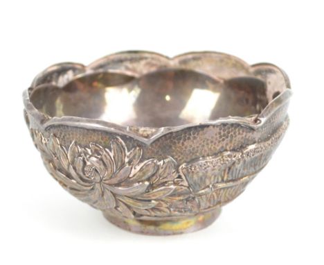 A late 19th/early 20th century Chinese Export white metal bowl with shaped rim and embossed floral decoration, bearing two ch