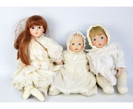 A group of dolls of bisque porcelain headed dolls with glass eyes, some with open mouths and teeth, variously dressed in deta