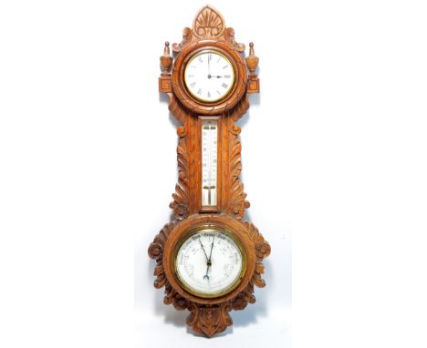 An early to mid-20th century oak carved combined barometer, clock and thermometer, with finials, foliate carving and decorate