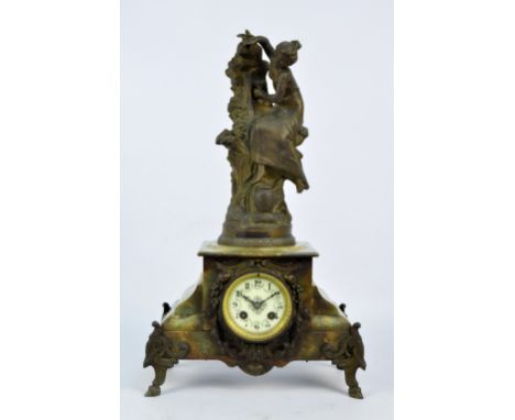 A French green onyx mantel clock surmounted by spelter figure entitled 'A la Fontaine' after F. Moreau, the enamelled circula