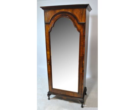 A late 19th century walnut mirror door wardrobe with single internal shelf above hanging space with rail and two pegs, with s