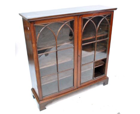 A mahogany two door glazed bookcase with three interior shelves and bracket feet, width 111.5cm.