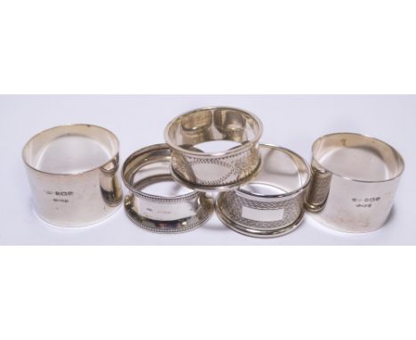 A small collection of hallmarked silver napkin rings comprising a pair of plain form bearing Irish import marks, Docker and B