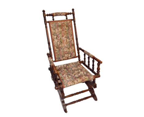 An American oak tapestry upholstered bobbin turned rocking chair.