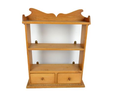 A small pine hanging wall shelf with two base drawers and shaped apron, width 51cm.