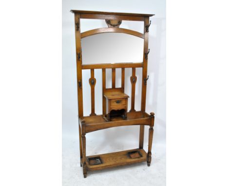 A late 19th/early 20th century Arts and Crafts style oak hall stand with mirror above central cupboard, single short drawer a