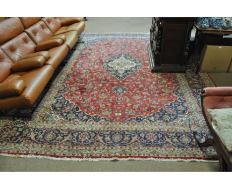 A good and large Kashan rug with central medallion against red ground within triple tone border of cream, light and dark blue