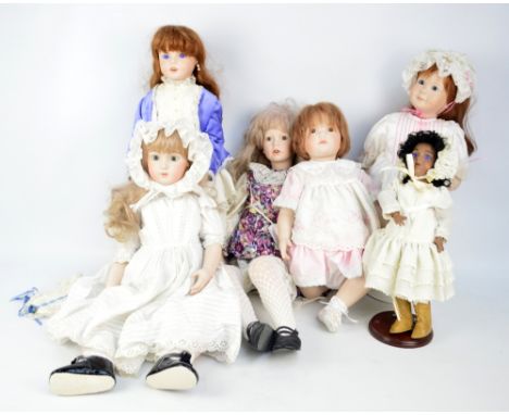 A group of bisque porcelain headed dolls, the majority with glass eyes and painted features, some with open mouths and teeth,