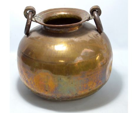 A large copper and brass globular pot with twin ring handles and part hammered body, height 37cm.