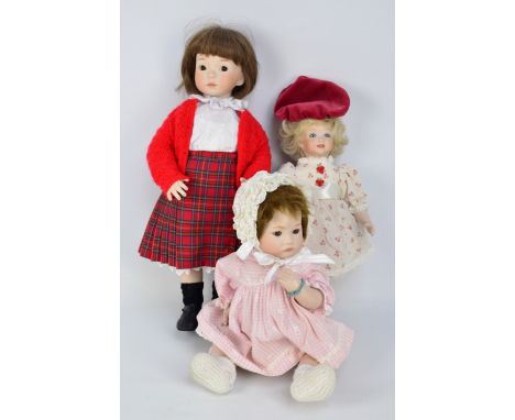 A group of predominantly porcelain headed dolls with glass eyes and painted features, some with open mouths and teeth, stuffe