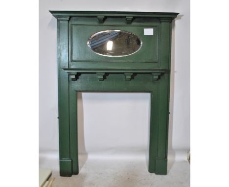 A green painted Edwardian fire surround with moulded mantel above bevelled oval mirror, simple shelf and moulded jambs, width