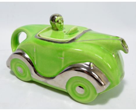 A novelty Art Deco 'Car' teapot, with green body, painted silver lustre with number plate 'OKT42', impressed marks to base, l