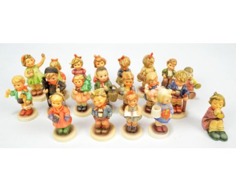 A group of over fifteen Hummel figures of children in varied poses and outfits.