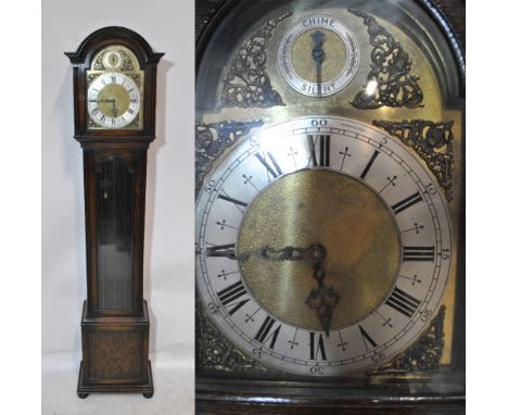 A 20th century oak long case clock with domed top above brass dial and silvered chapter ring set with Roman numerals, inscrib