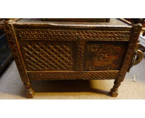 An Afghan dowry chest, the front with profusely carved geometric decoration and sliding right panel, on turned supports to bl