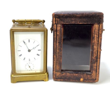 A circa 1900 French brass repeater and alarm carriage clock with circular chapter ring set with Roman numerals above subsidia