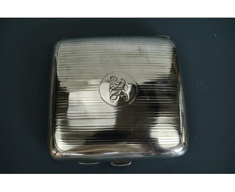 A 1920s silver cigarette case, decorated with banded engine turning centred by a circular cartouche with engraved monogram. 9