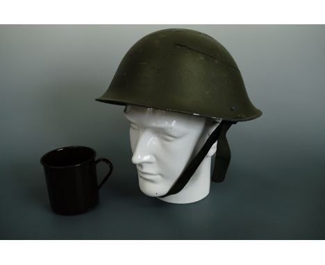 A British army Mk 5 steel helmet together with an enamelled mug