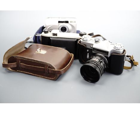 A vintage Zenit-E 58 mm film camera together with two other cameras