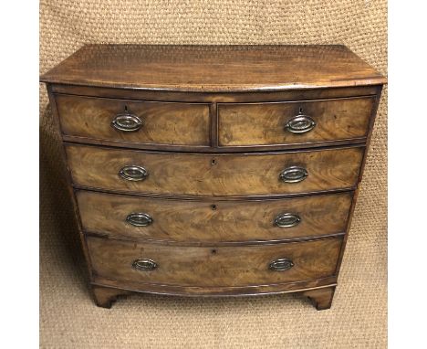 A George III mahogany bow-fronted chest of drawers, having oval stamped brass back-plate bale handles and square bracket feet